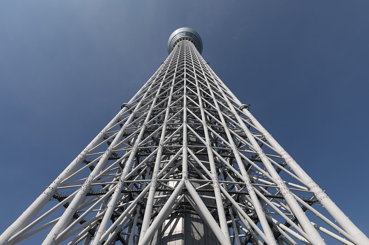 Tokyo Skytree photographed from directly below: the tower looms overhead, filling the sky and looking enormous and powerful